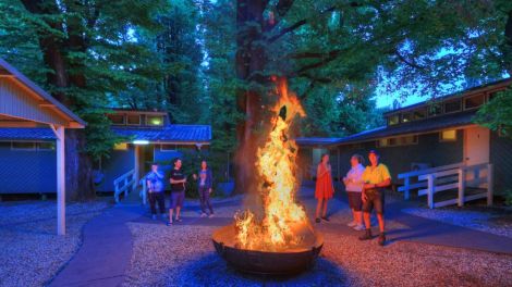 Guests chatting around a fire pit at Myrtleford Holiday Park